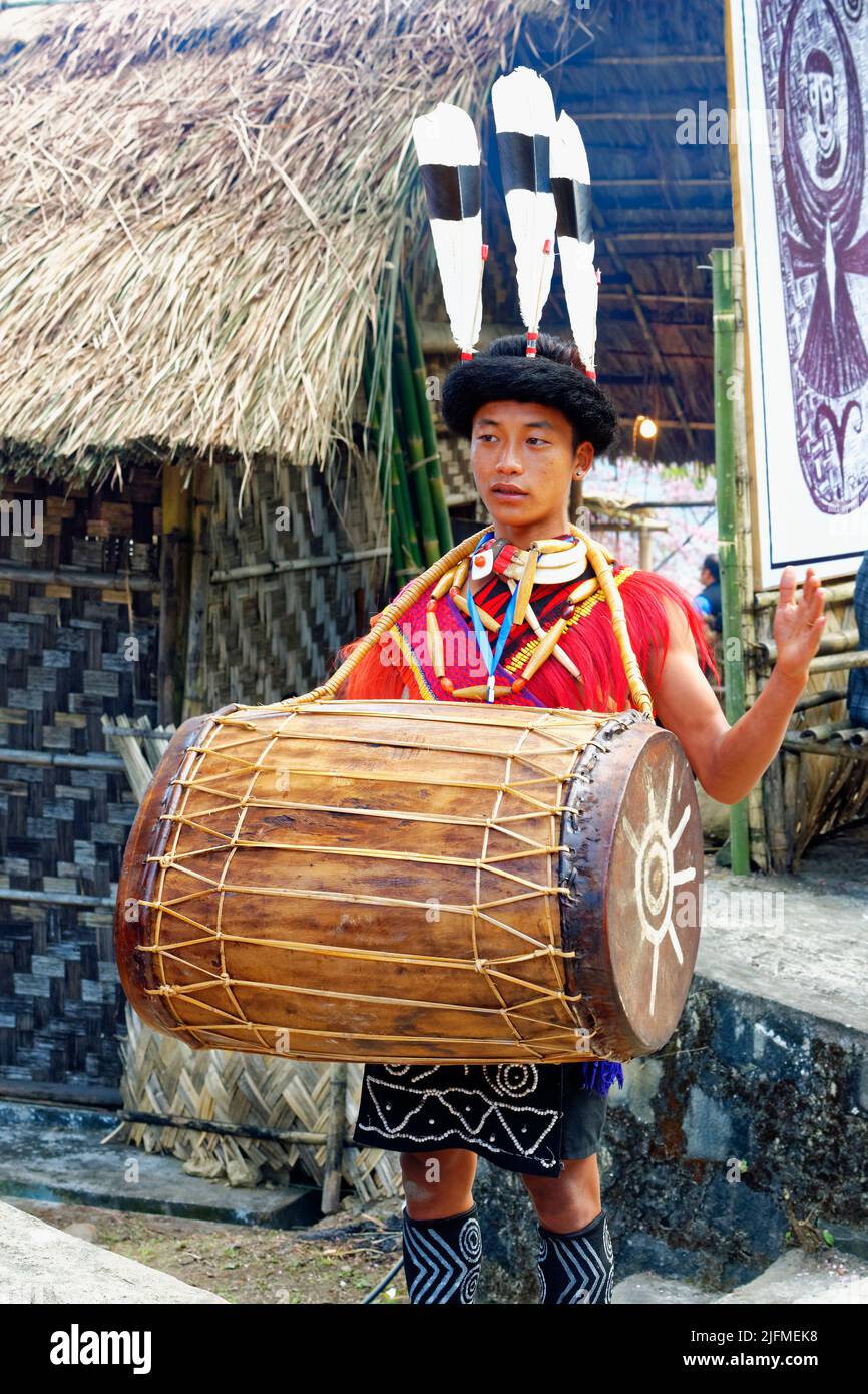 Naga tribal man in traditional outfit playing drum, Kisima Nagaland Hornbill festival, Kohima, Nagaland, India Stock Photo