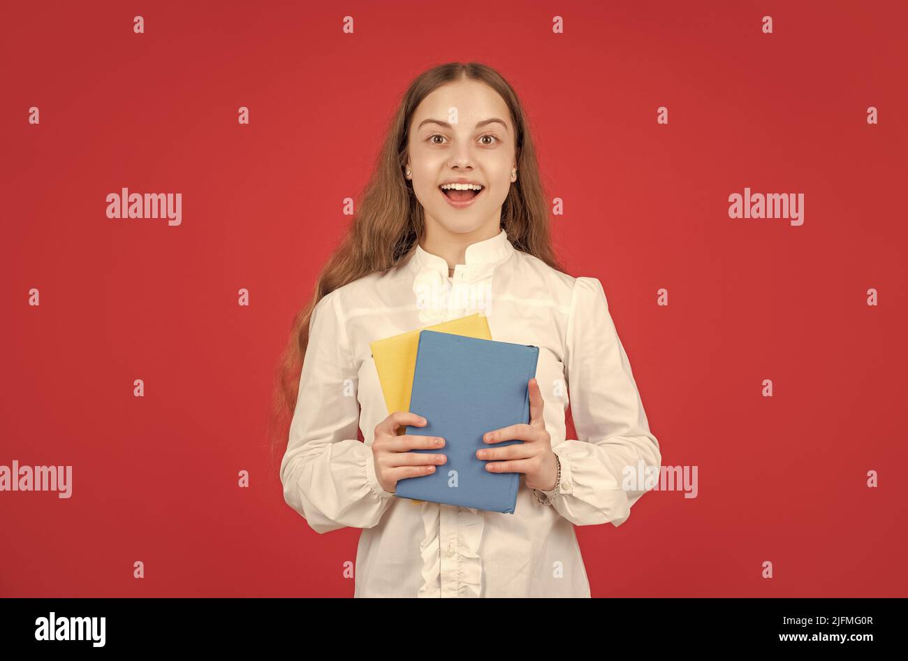 amazed child in white shirt ready to study do homework with book on red ...