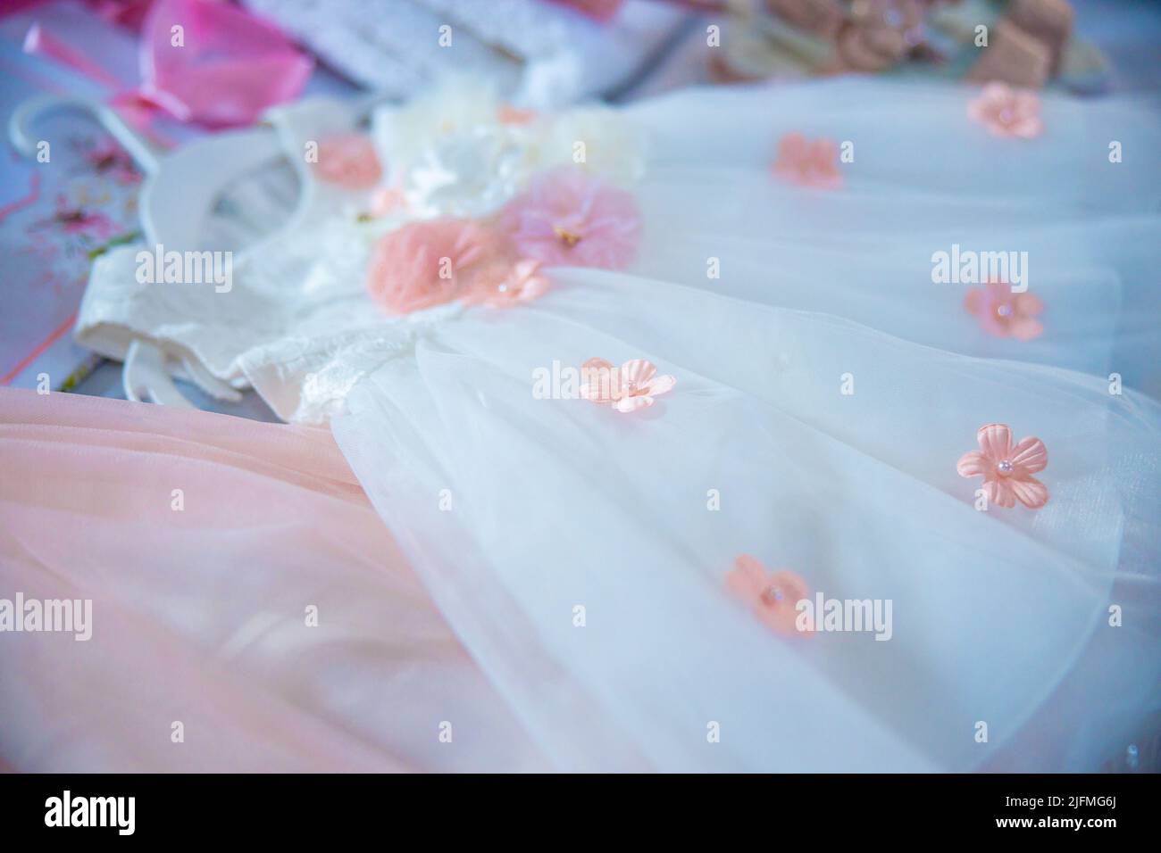 Baptism pictures. White gown baby with pink flowers outfit for religious celebration after birth. High quality photo Stock Photo