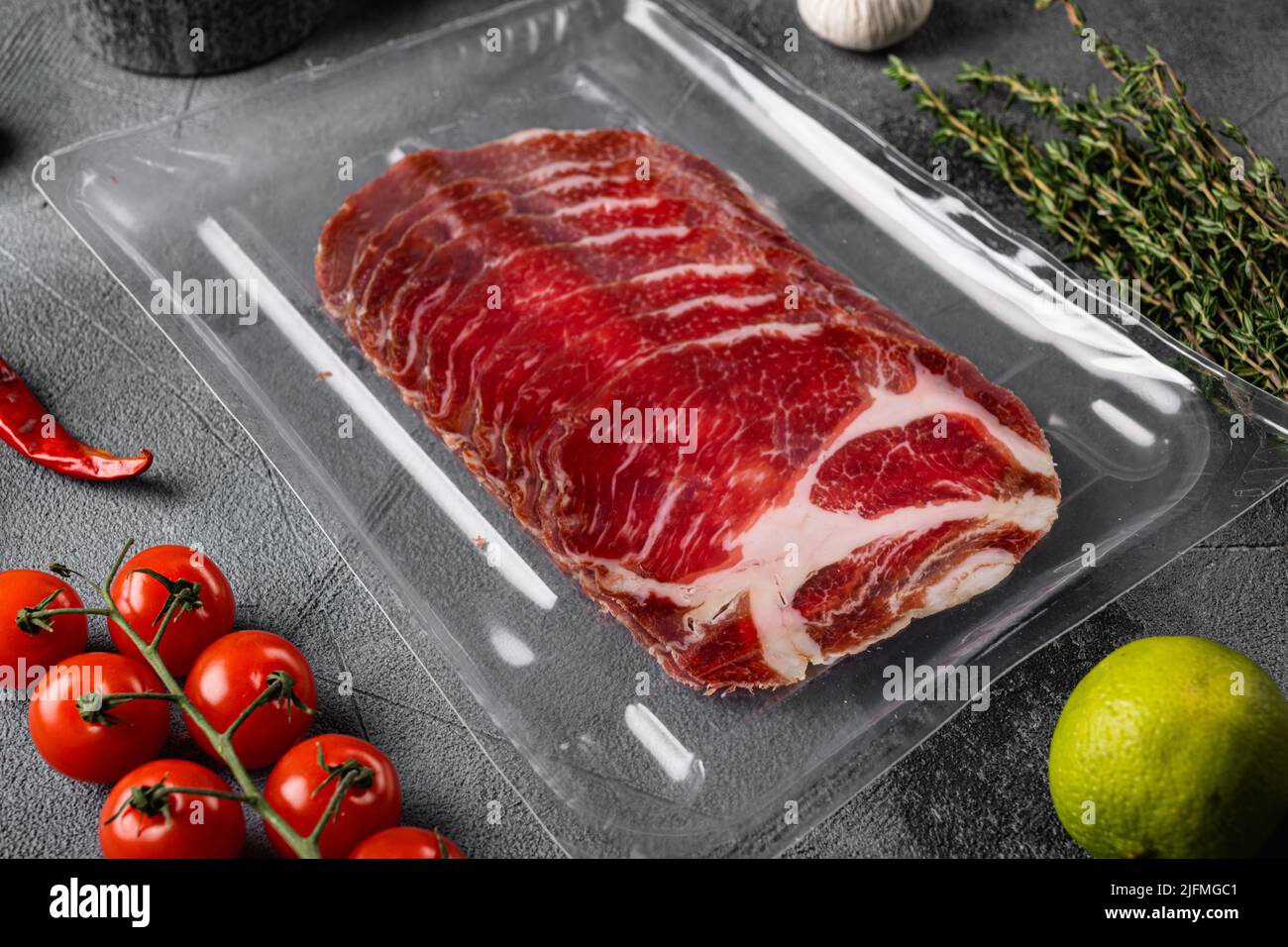 Vacuum packed cured coppa ham , on gray stone table background Stock