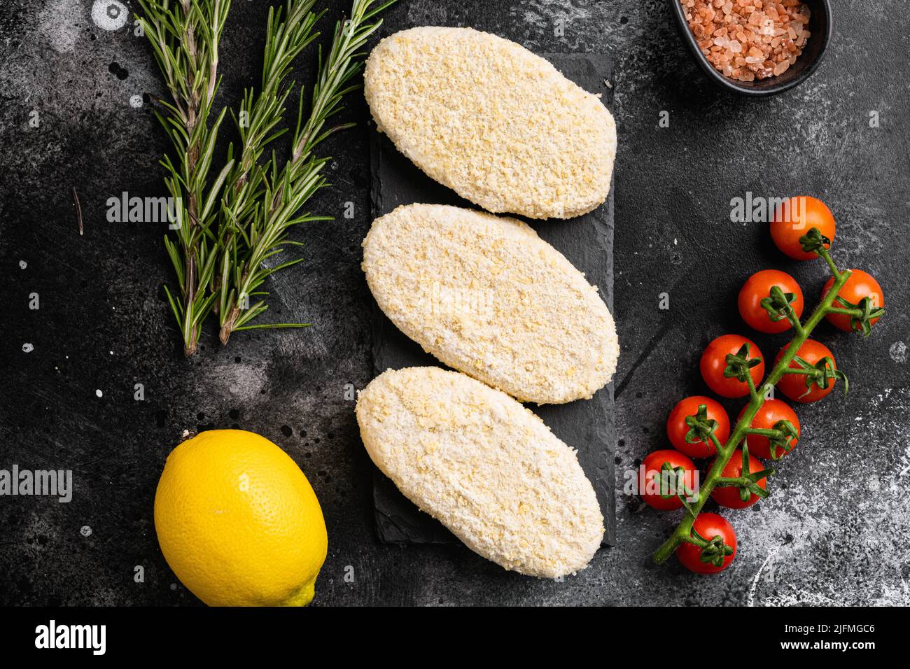 A fresh raw fishcake patties, on black dark stone table background, top ...