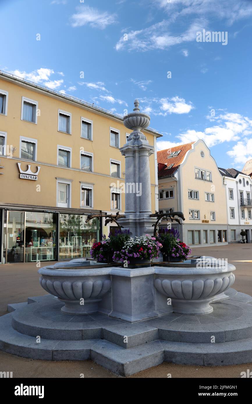 Fountain and neptun is overlooking the city centre of bregenz in vorarlberg, austria. Downtown in the heart of city during summertime with blue sky Stock Photo