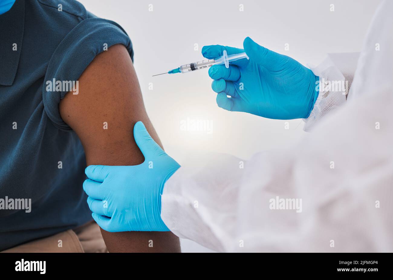 Hands of a doctor ready to inject a patient with the covid vaccine. Healthcare professional injecting a patient with corona virus cure cropped Stock Photo