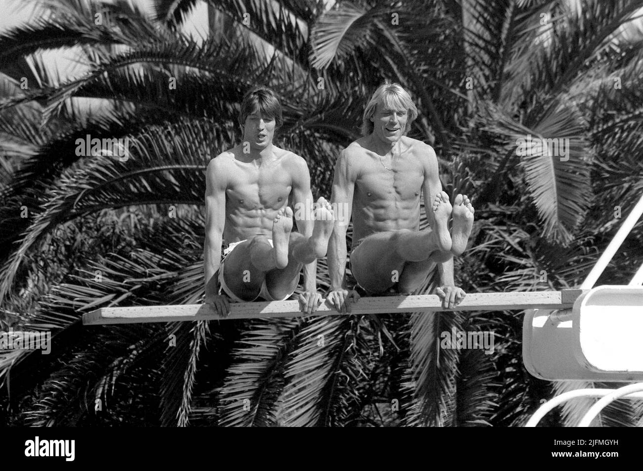 ARCHIVE PHOTO: Carlo THRAENHARDT will be 65 years old on July 5, 2022, Dietmar MOEGENBURG (left) and Carlo THRAENHARDT, Germany, high jumper, high jump, private, sit in forearm supports on a springboard at the swimming pool, at the high jumper training camp in Estepona Spain, 24.03. 1984, B/W recording. Stock Photo
