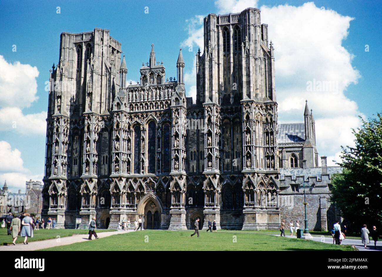 People walking past the west facade of Wells cathedral church, Wells, Somerset, England, UK early 1960s Stock Photo
