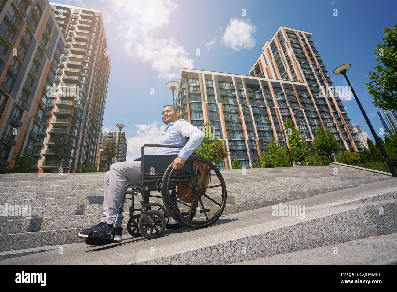 Young man seated in wheel chair going down stairs Stock Photo