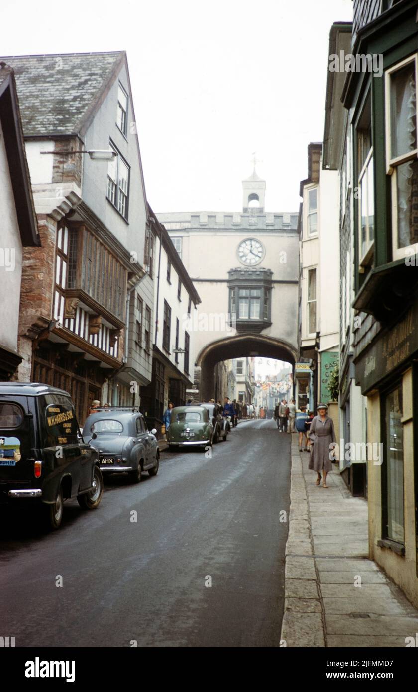Cars and people High Street, East Gate arch gateway, Totnes, Devon, England, UK early 1960s Stock Photo