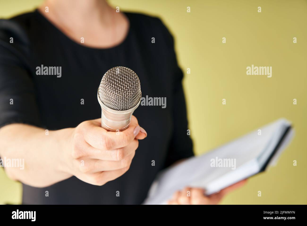 Journalist with microphone interviewing you. Cropped image of female reporter holding microphone to camera, Focus on microphone. journalism, broadcast Stock Photo