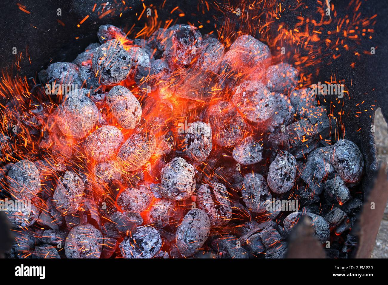 Glimmering heat from glowing charcoal to harden knives Stock Photo