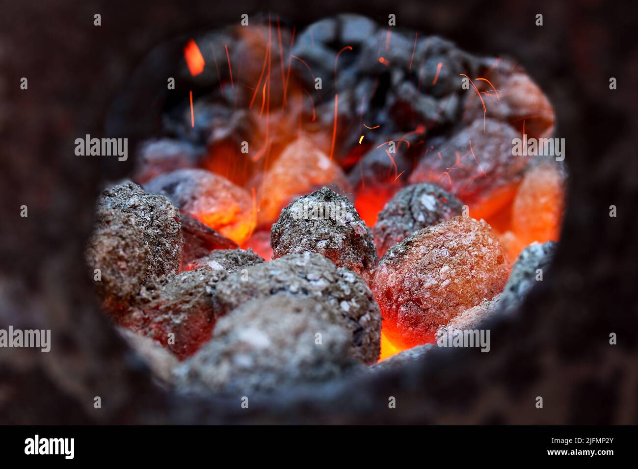 Glimmering heat from glowing charcoal to harden knives Stock Photo