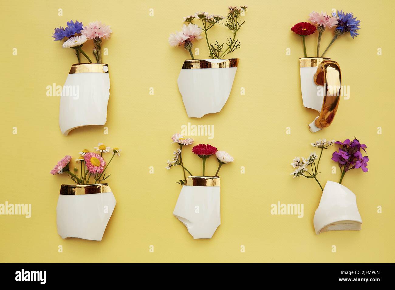Creative aesthetic broken cup's pieces with wildflowers, miniature