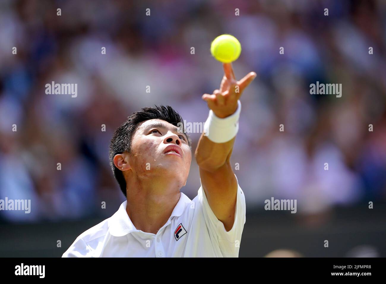 Brandon Nakashima serves during his Gentlemen's singles fourth round match against Nick Kyrgios on centre court on day eight of the 2022 Wimbledon Championships at the All England Lawn Tennis and Croquet Club, Wimbledon. Picture date: Monday July 4, 2022. Stock Photo