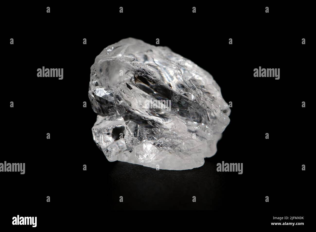 Natural rough goshenite gemstone on dark background , goshenite is a member of beryl gemstone group (ex. emerald, aquamarine, morganite ) Stock Photo