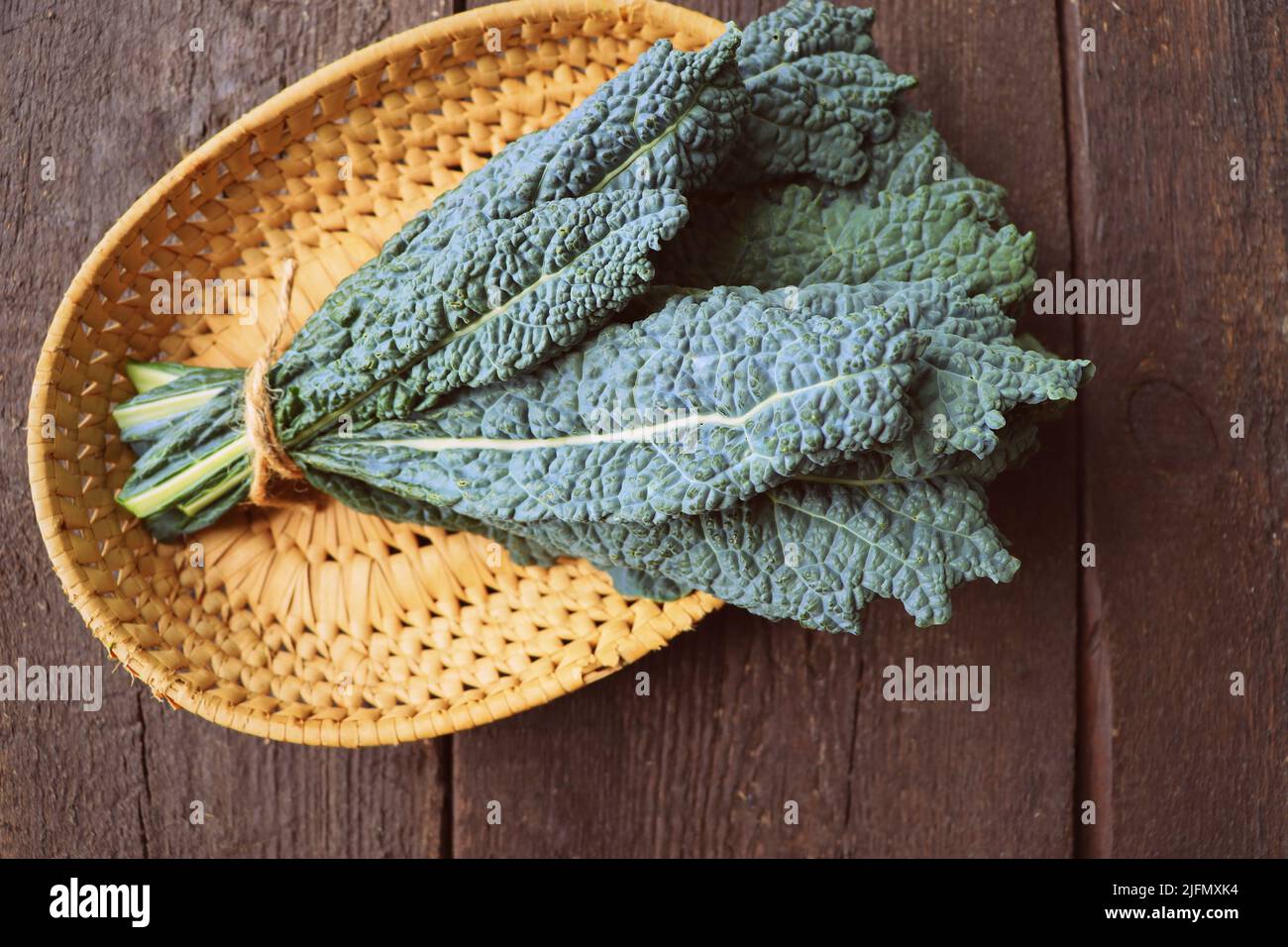 Fresh black cabbage leaves on wooden background. Black kale. Italian food. Healthy eating cooking step, ready to prepare vegetarian food Stock Photo