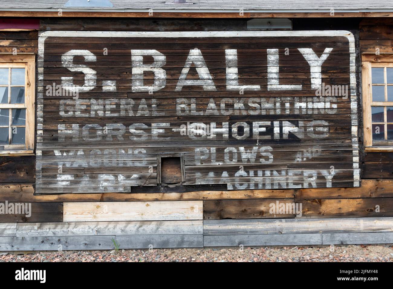 An old and faded historic 1911 sign on the side of the Sam Bally blacksmith shop in Grand Marais, Minnesota Stock Photo
