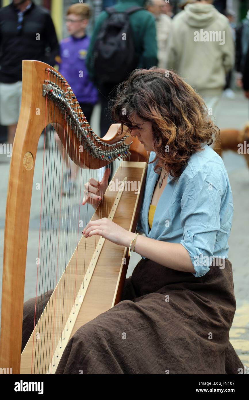 Street musician playing the harp at Galway in the West of Ireland Stock Photo