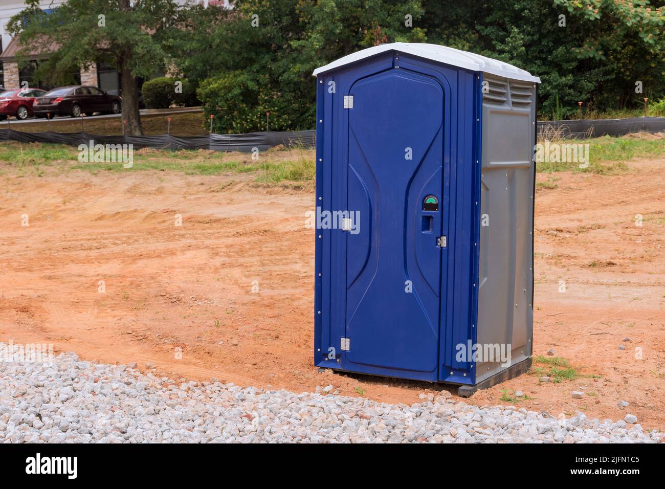Workers using a portable restroom near on a construction site Stock Photo
