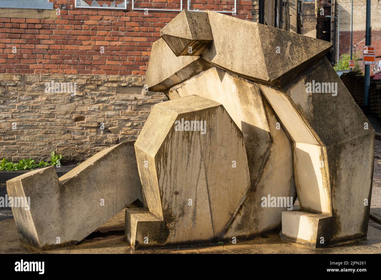 The Seated Man Rising geometric sandstone sculpture by Terry Hamill, in Little Germany area of the city of Bradford, UK, symbolising arts and culture. Stock Photo