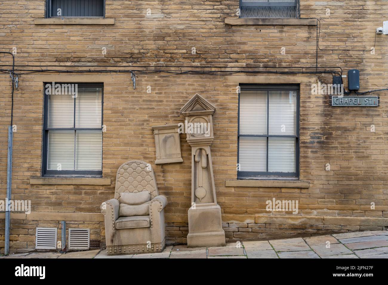 Grandad’s Clock and Chair stone furniture sculpture by Timothy Shutter, situated in Chapel Street in Little Germany area of the city of Bradford, UK. Stock Photo