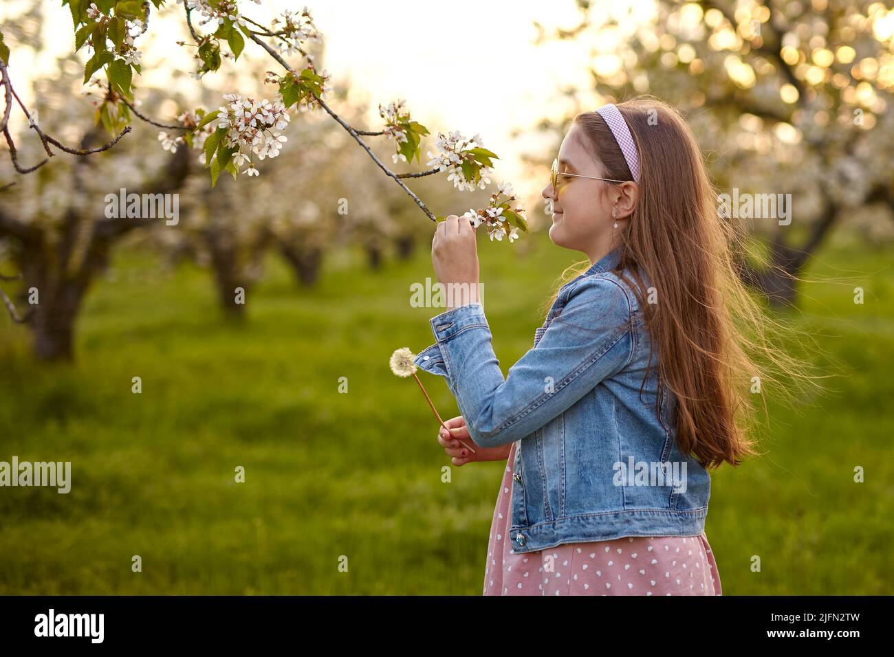 Little happy child girl in beautiful spring garden Stock Photo - Alamy