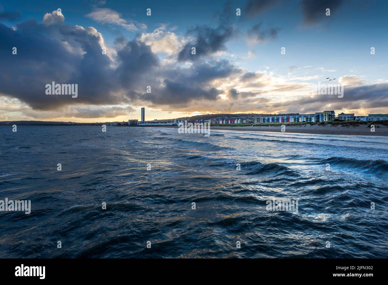 Editorial Swansea, UK - July 02, 2022: Coastal housing and a full tide at sunset on Swansea Bay in South Wales UK Stock Photo