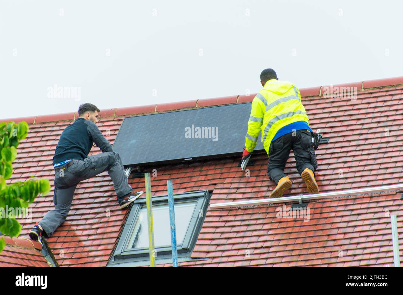 Installing solar panels on roof Stock Photo - Alamy