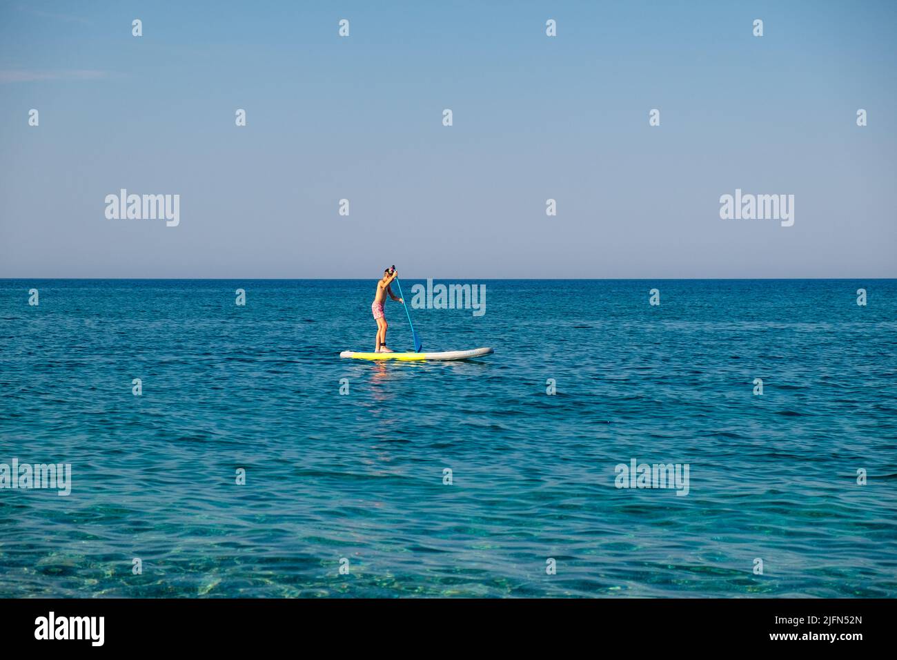 A young man on his Stand up paddleboard Stock Photo