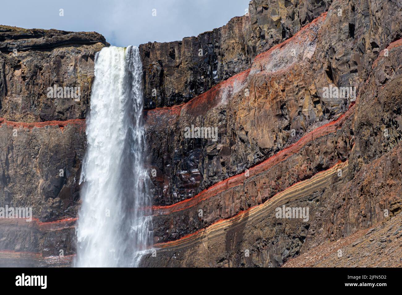 Detail of the upper part of waterfall Hengifoss with colored cliff in eastern Iceland Stock Photo