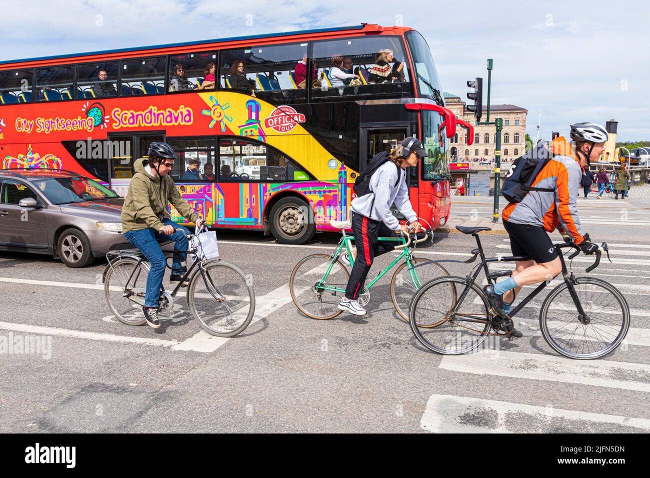 Cyclists and a sightseeing tour bus in Skeppsbron, central Stockholm, Sweden Stock Photo