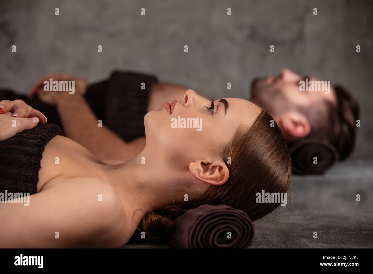 Young man and woman lying down on massage beds at luxury spa and wellness center Stock Photo