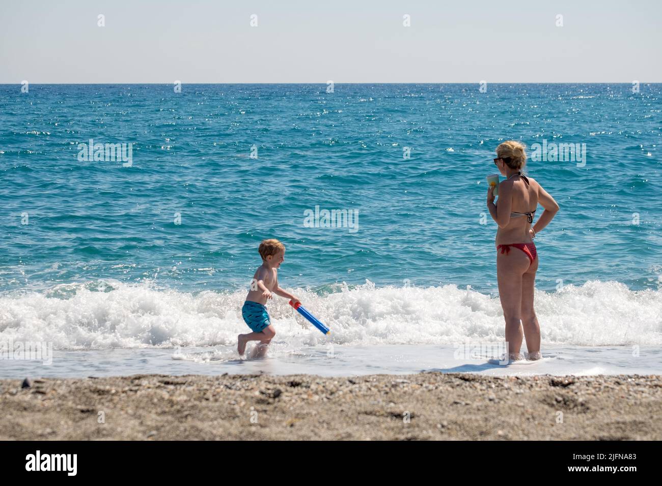 Mother playing with her son in the beach Stock Photo