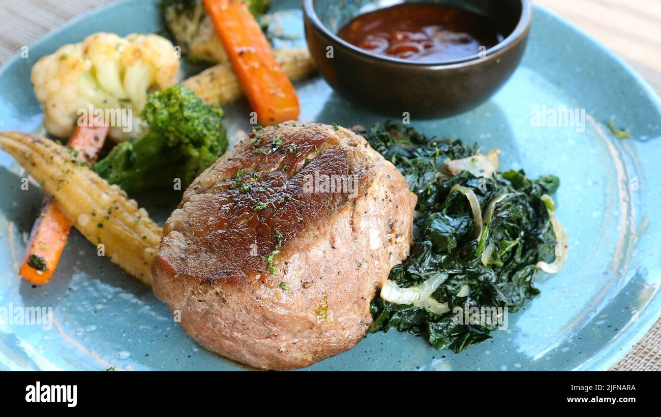 Grilled tenderloin steak served on blue plate in luxury restaurant