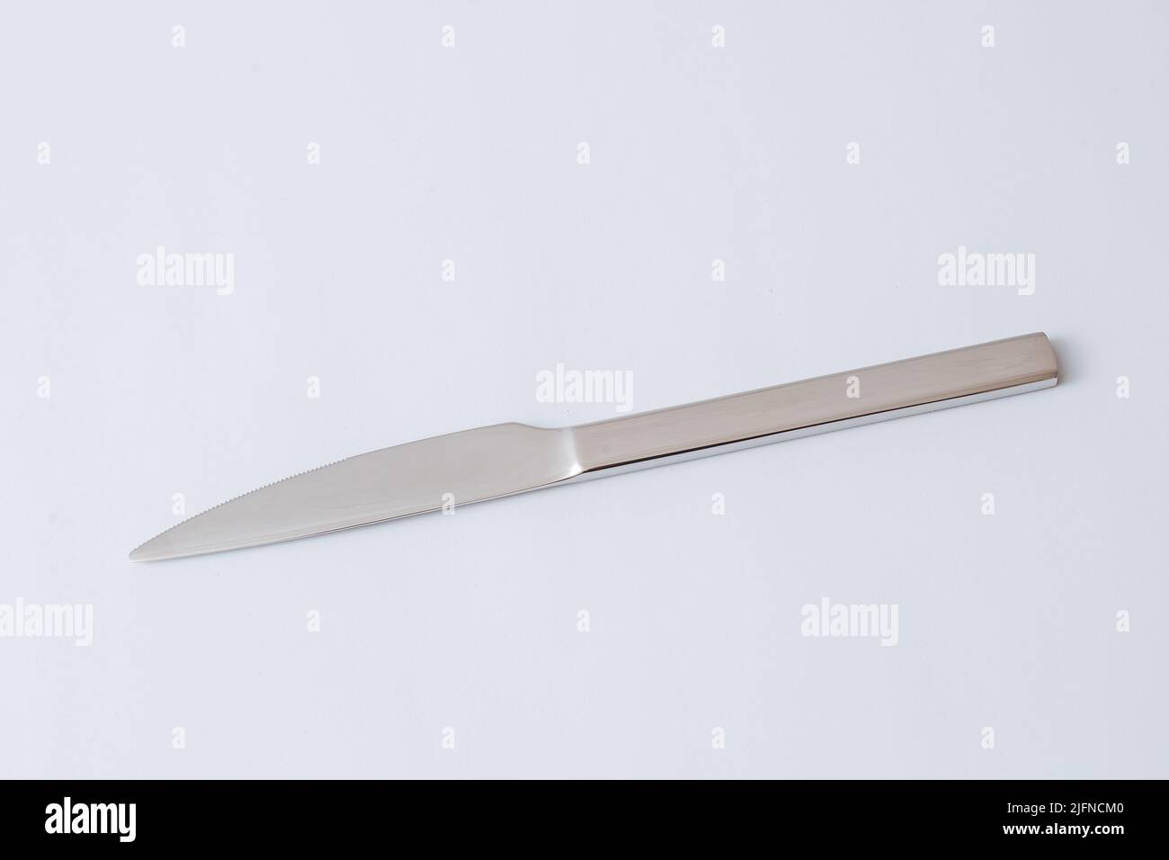 Stainless steel knife on white background, table knife, copy space. Stock Photo