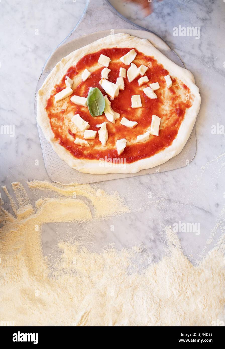background photo of some pizzas on marble top with flour and traditional italian ingredients