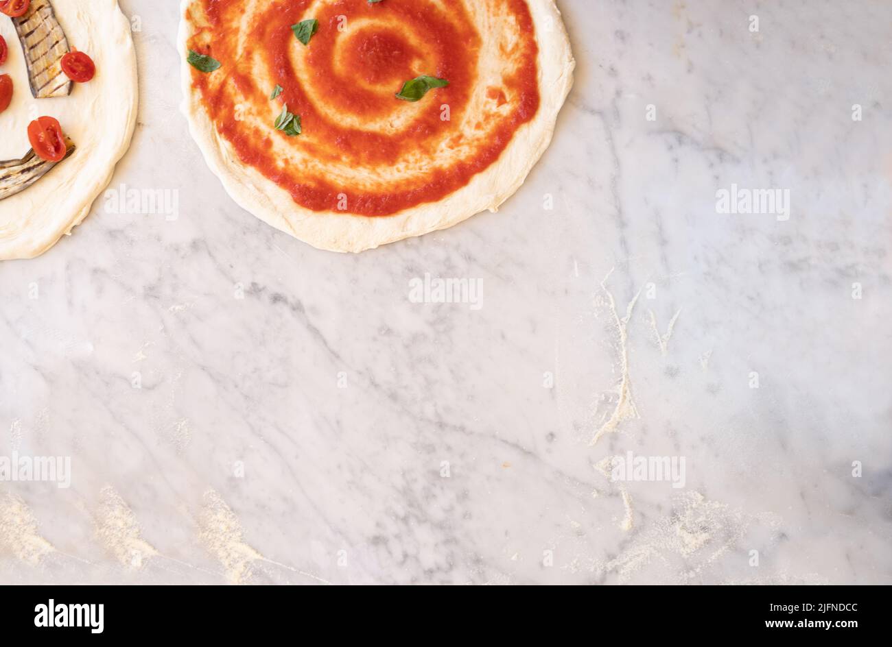background photo of some pizzas on marble top with flour and