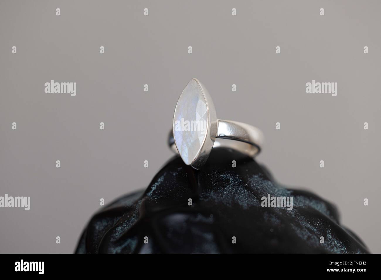 A silver moonstone ring on a black surface Stock Photo