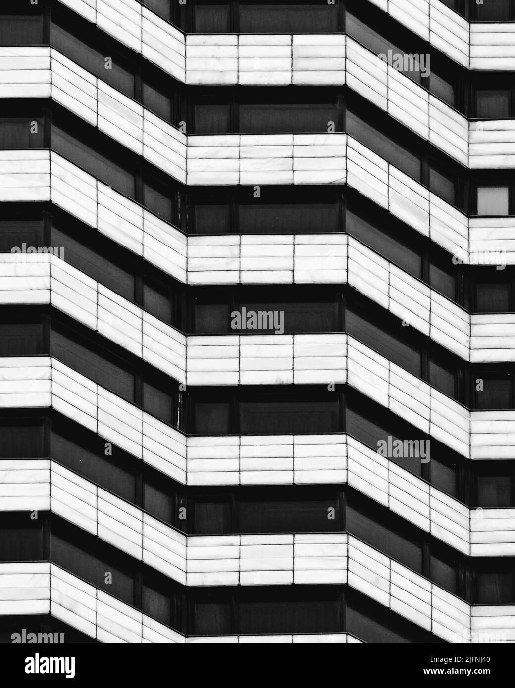 A vertical grayscale shot of a modern symmetrical apartment building Stock Photo