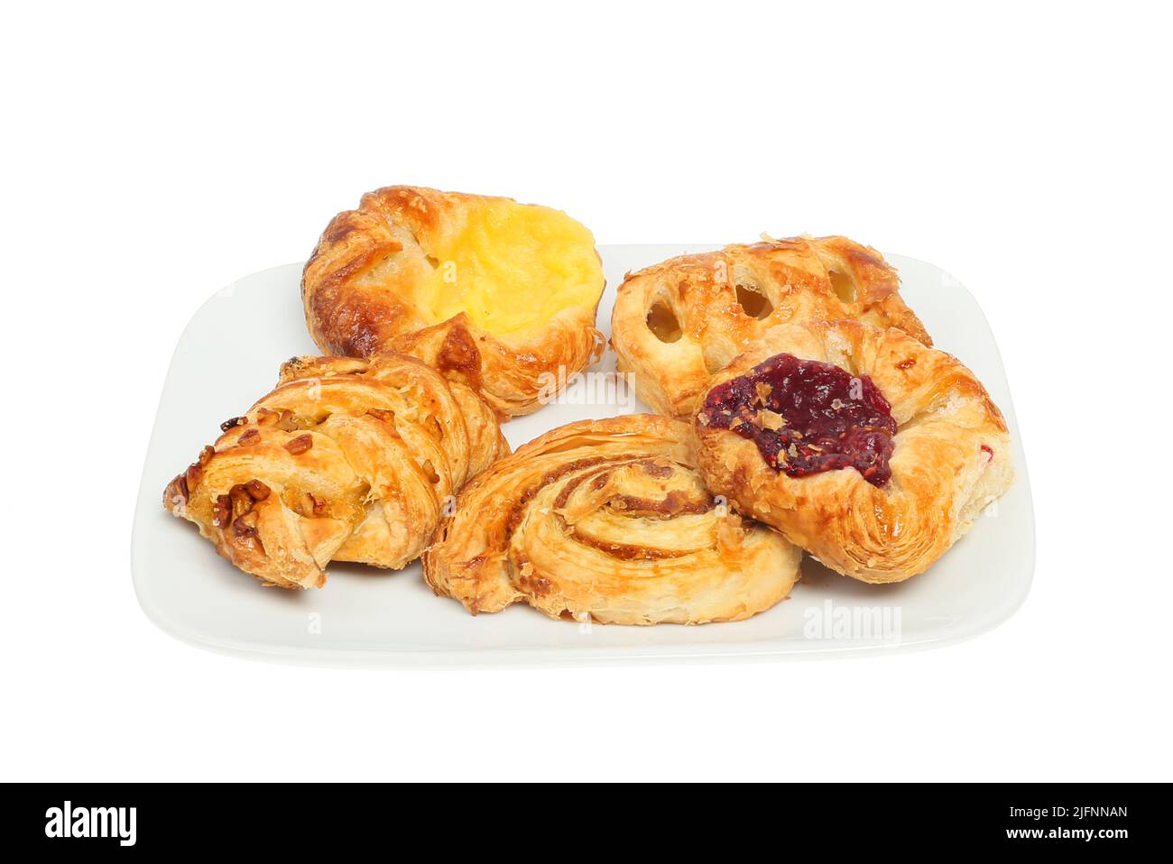 Selection of mini Danish pastries on a plate isolated against white Stock Photo