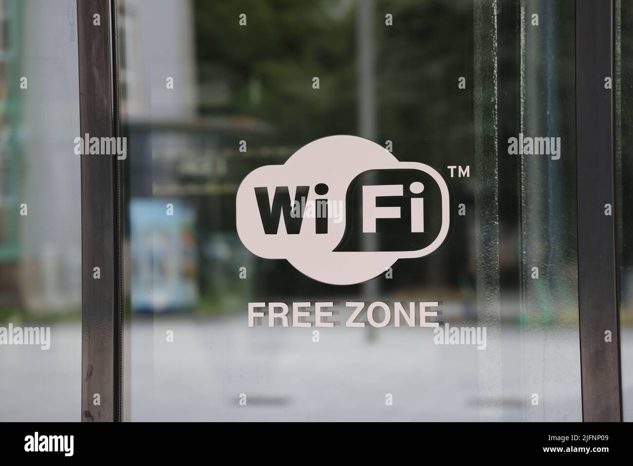 Sign with text WiFi free zone on a mirroring glass door in Bratislava, Slovakia Stock Photo