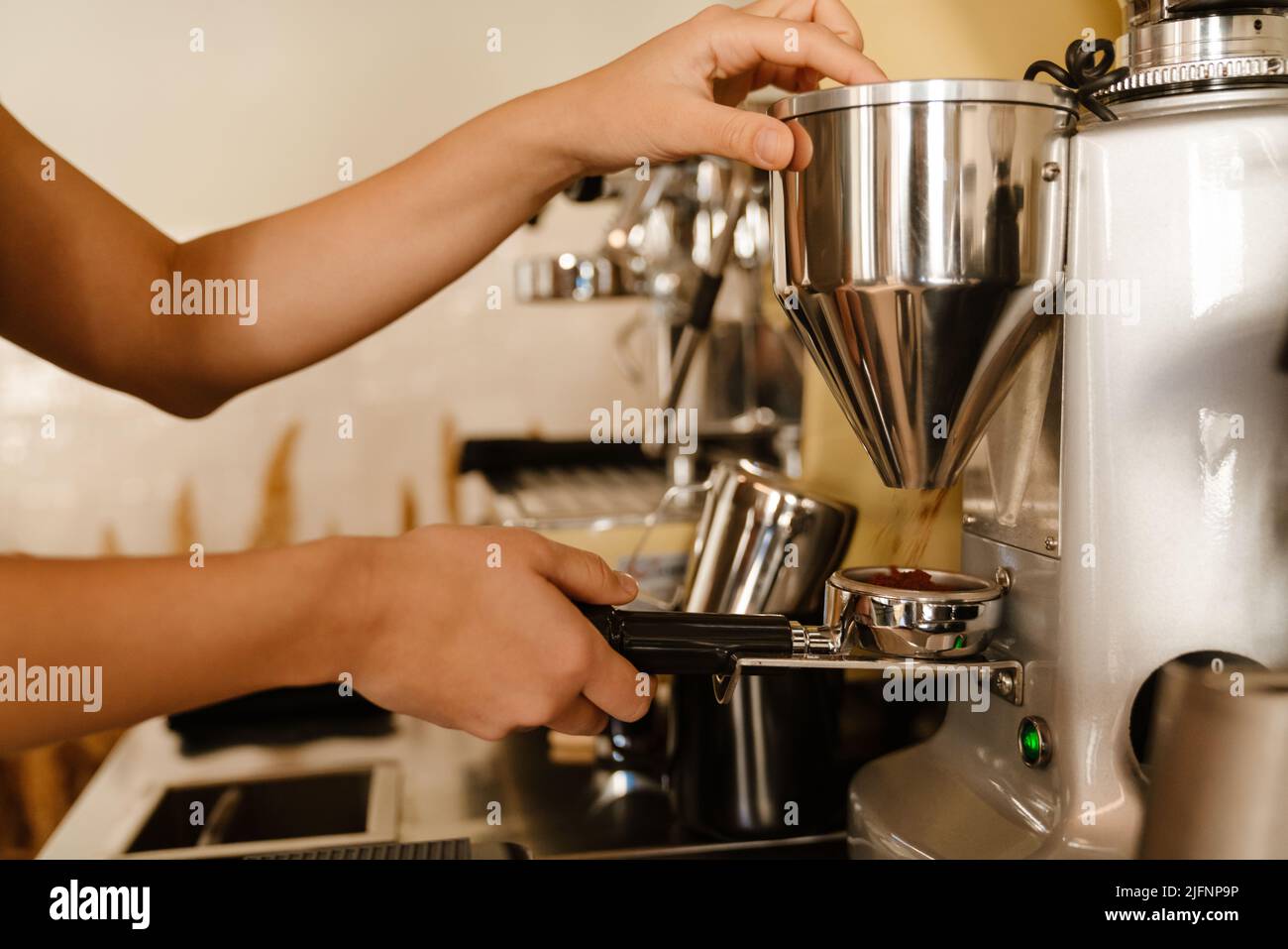 Young barista making coffee while working in cafe Stock Photo