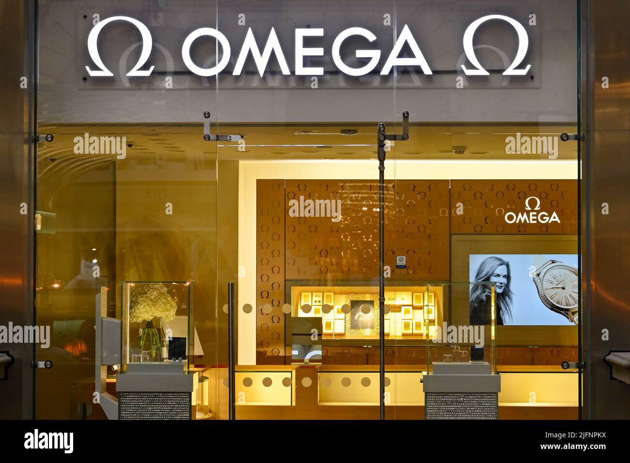 London, England - June 2022: Illuminated sign above the entrance to a branch of Omega in in the City of London Stock Photo