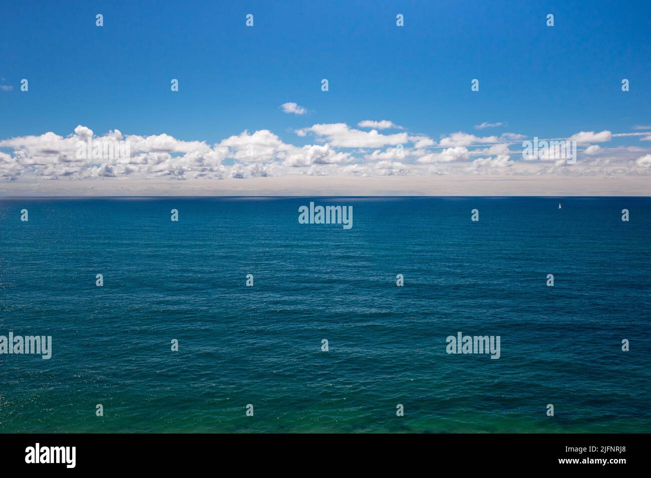 The vast and deep Atlantic ocean, blue sky and white clouds on the horizon in Portugal. Front view seascape background with empty space for text Stock Photo