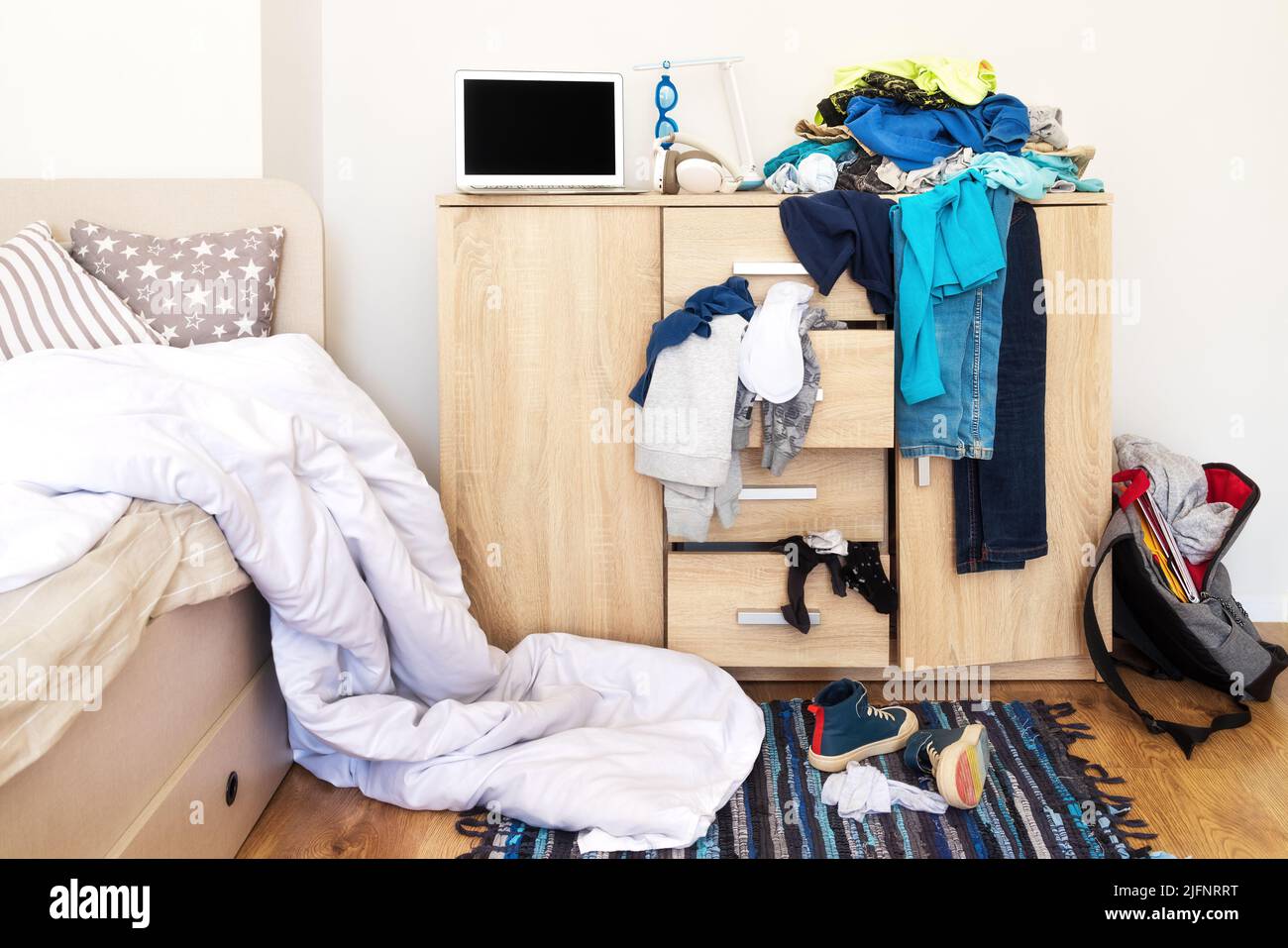 mess in a teenager's room. Clothes are strewn across the chest of drawers, floor Stock Photo