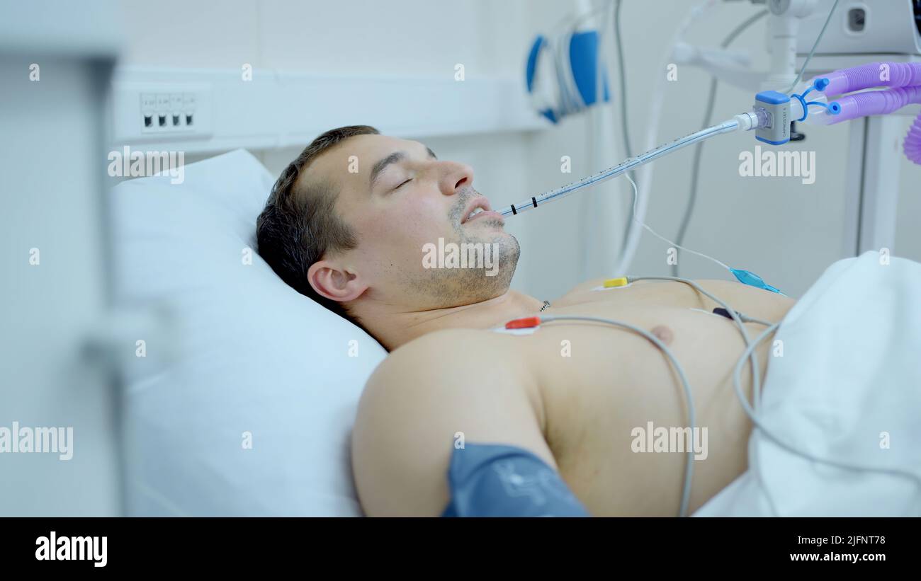 Man opened eyes after anesthesia. Action. Man in hospital bed after