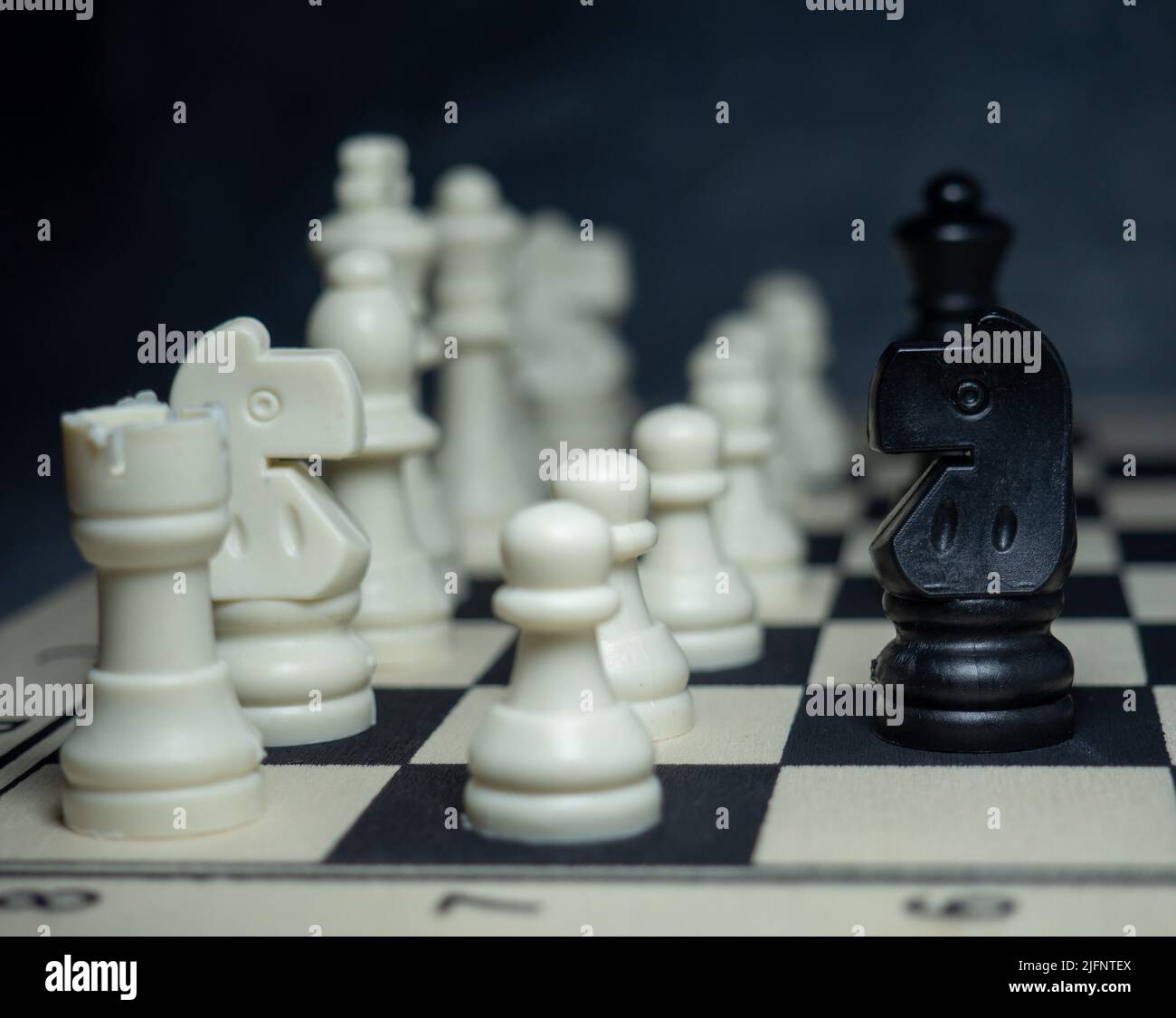 A completed chess game setup on a table with opposing chairs in a dark room  backlit by a bright window light - 3D render Stock Photo - Alamy