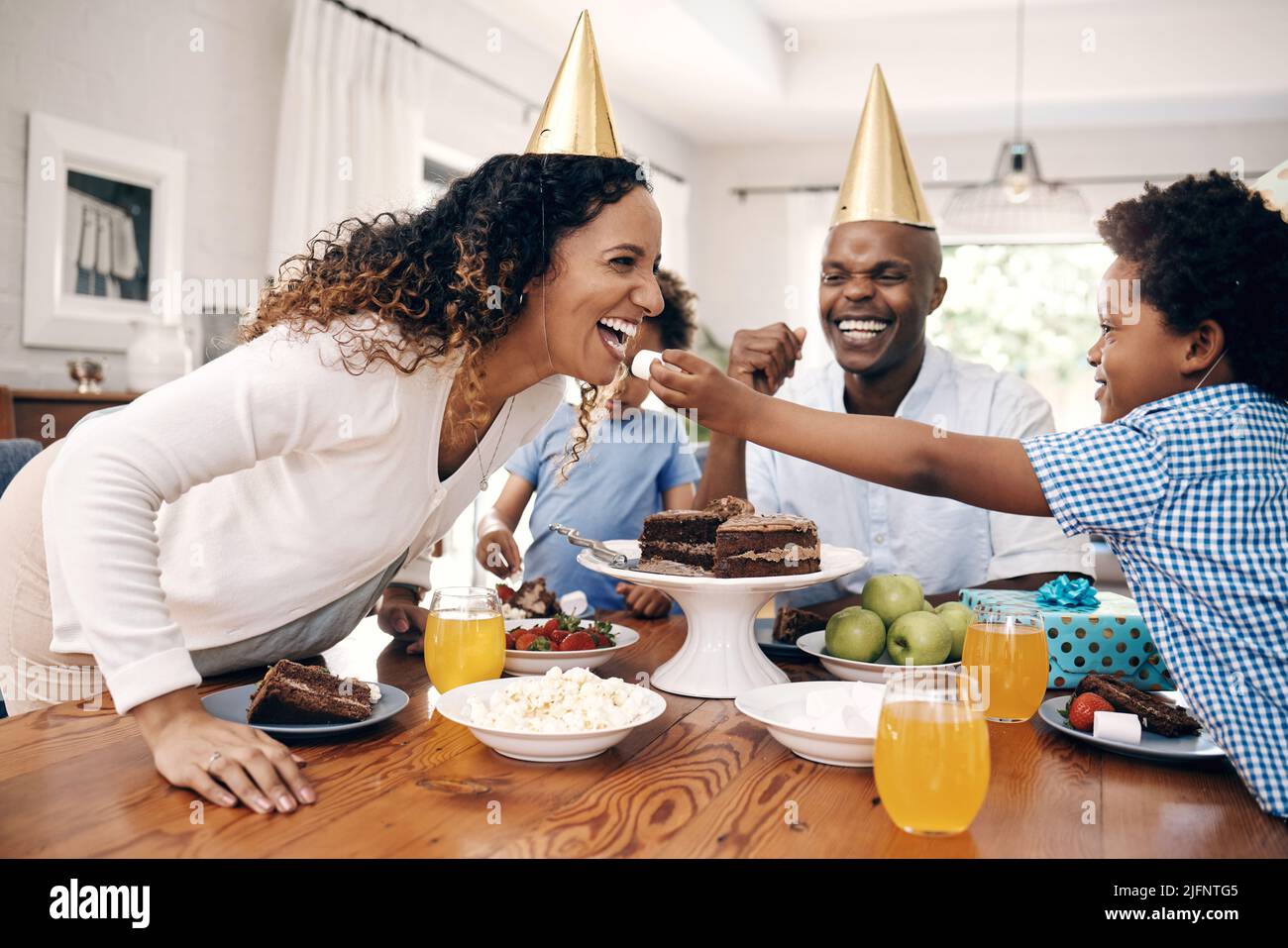 Little boy feeding his cheerful mother a marshmallow while celebrating