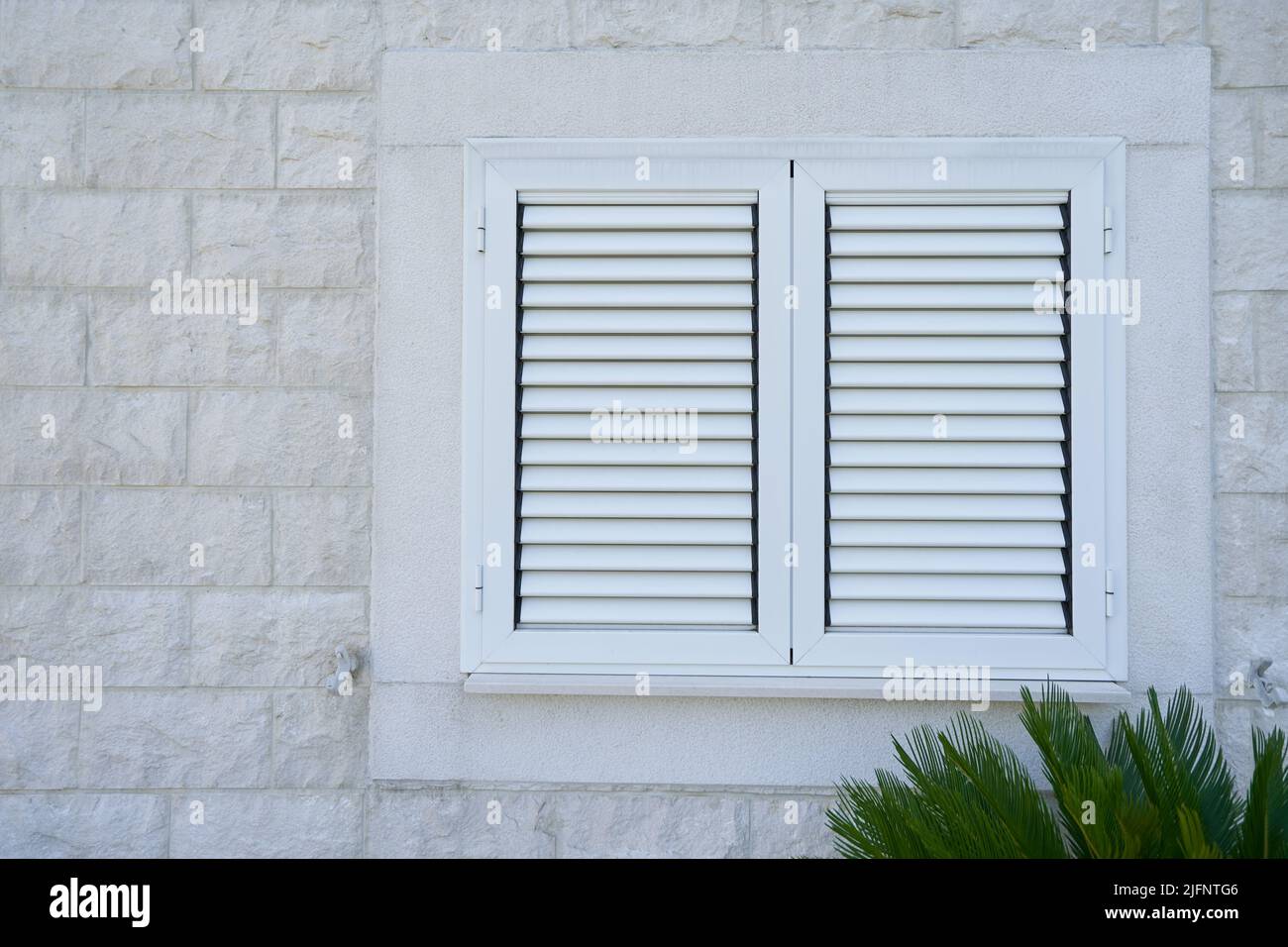Plastic external window shutters on a residential building Stock Photo