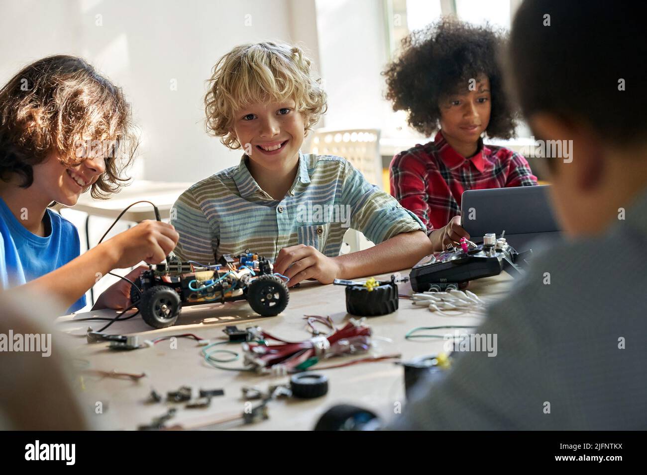 Happy schoolboy with group of classmates on science lab work at school. Stock Photo
