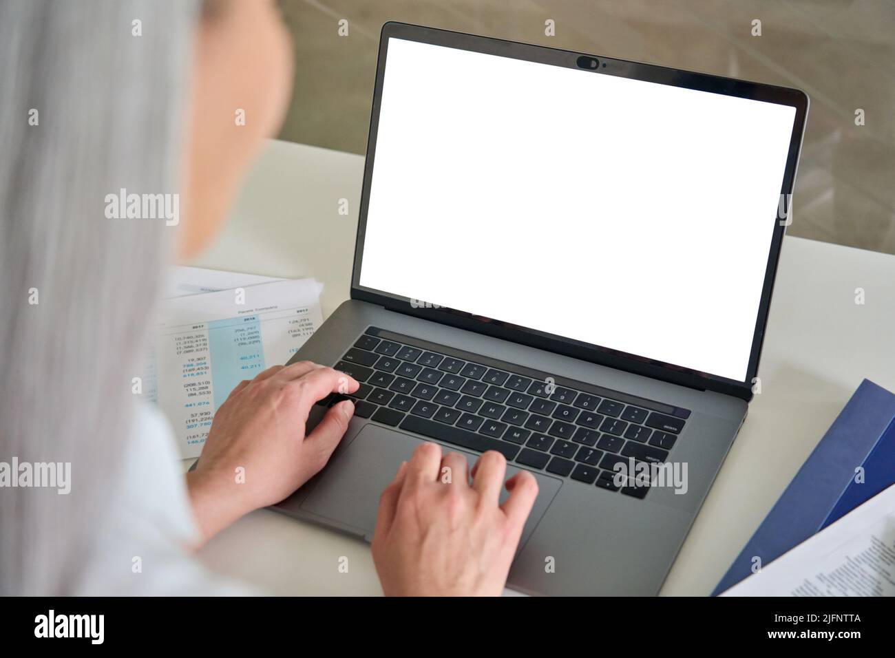 Female older businesswoman typing on laptop computer keyboard with empty screen. Stock Photo