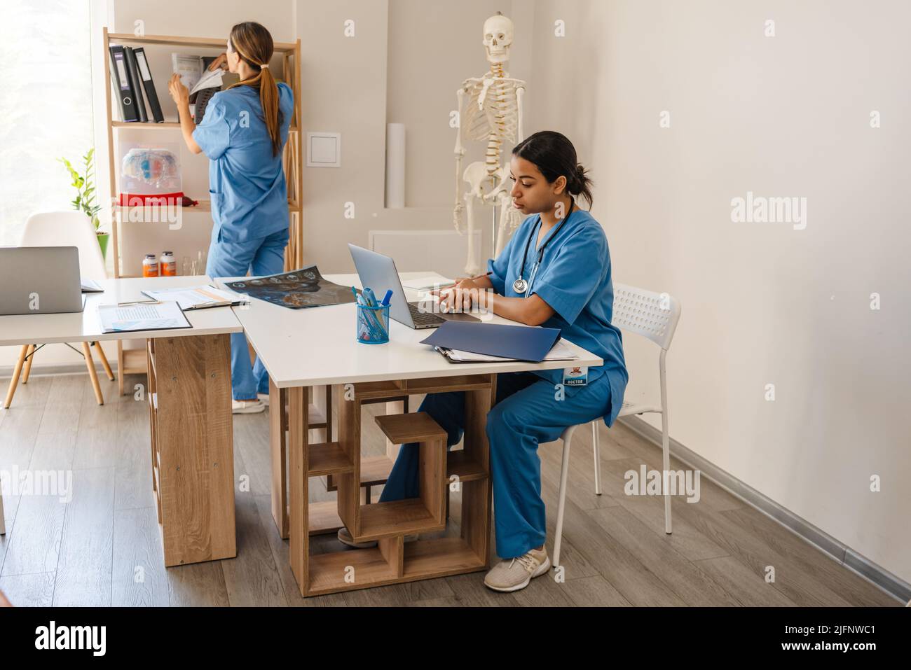 Multiracial women doctors working together in office indoors Stock ...